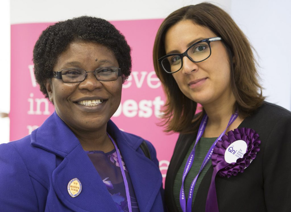 Image of a Queen's nurse with a member of QNI staff