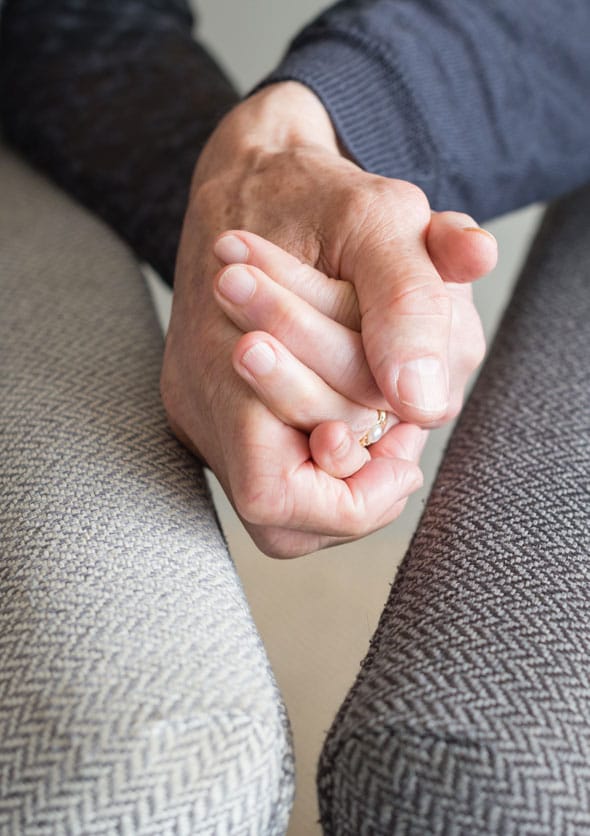 A older couple holiding hands in a counselling session close up view